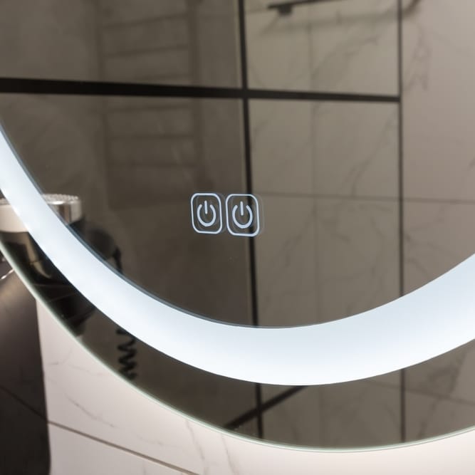 Miroir Rond LED Lumineux avec Touches Tactiles de Salle de Bain Miroir rond LED avec deux boutons tactiles rétroéclairés sur un fond de carrelage effet marbre.